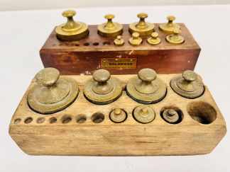 Lote #031 - Dos soportes para pesas de balanza con pesas de bronce - 25x10cm y 30x11cm