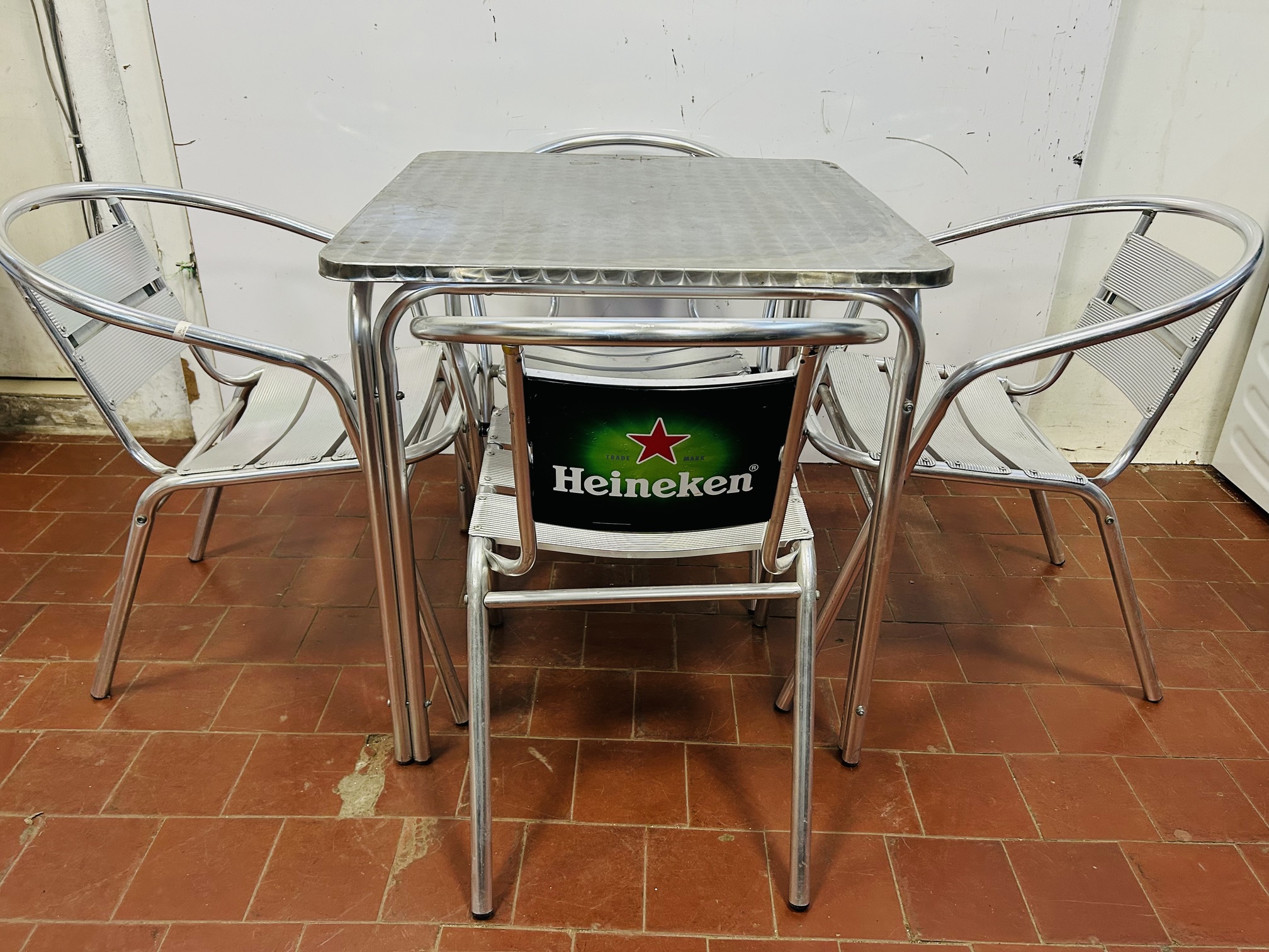 Lote #047B - Mesa y cuatro sillas apilables en aluminio - 70x70x72cm