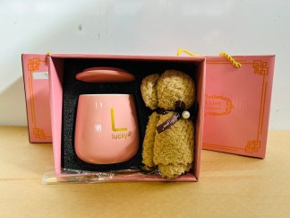 Lote #017 - Dos cajas para regalería que c/u contiene: una taza en cerámica esmaltada de color + cuchara color oro + toalla pequeña (color rosa)