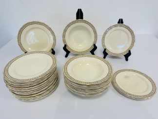 Lote #074 - Platos de la marca Grindley (origen Inglaterra) modelo Cream Petal, de borda ondulado con filete y guarda dorada. 21 platos llanos (uno con cascadura en borde, 12 platos hondos y 4 platos de postre (uno con cascadura en borde)